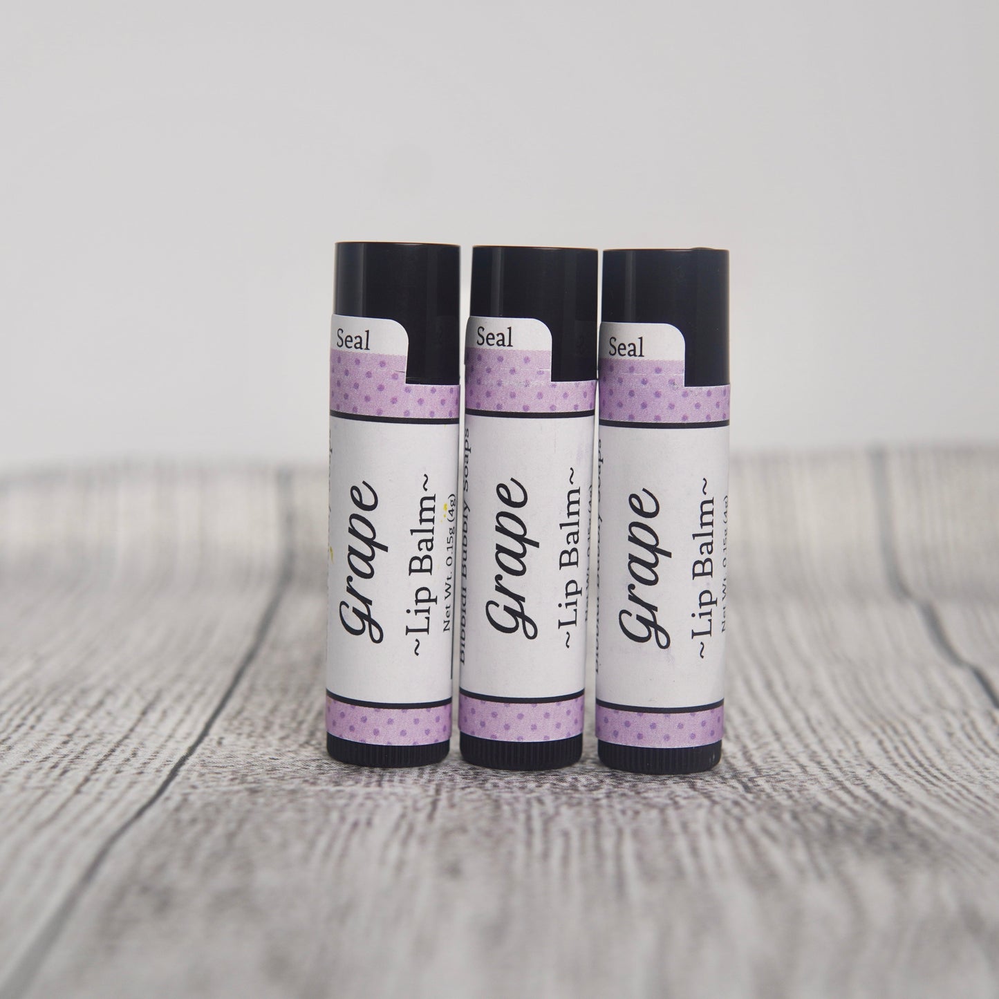 Grape lip balm labeled with name and ingredients.